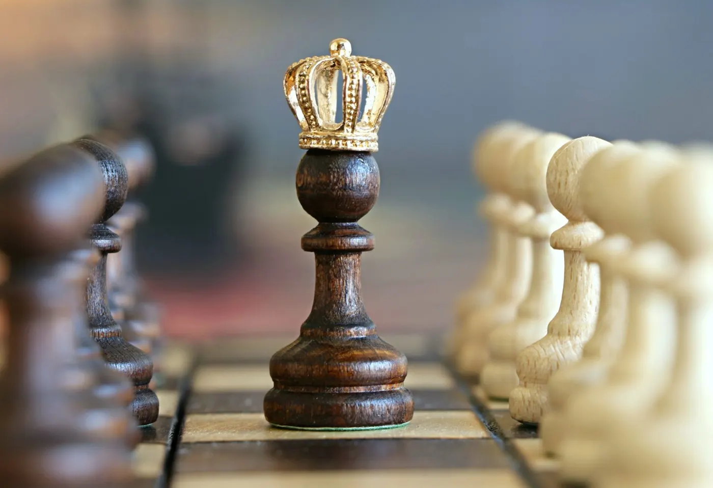 A crowned chess pawn standing out from the other pieces