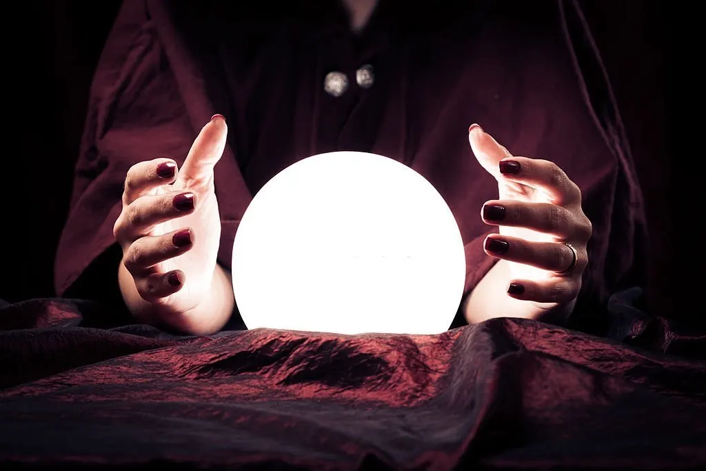 Hands around a glowing crystal ball