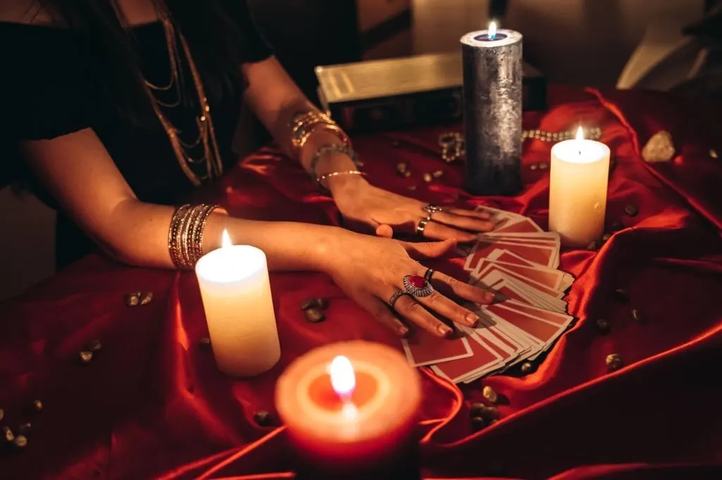 Tarot cards and candles on a red cloth during a psychic reading